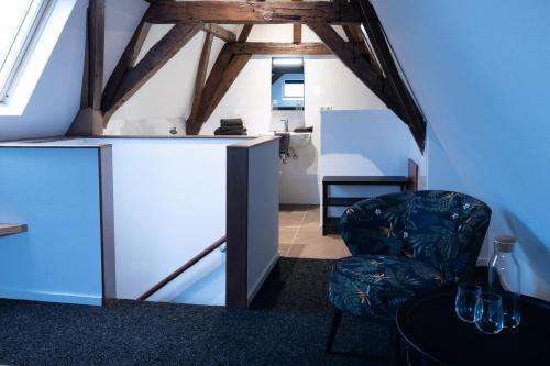 een woonkamer met een stoel en een koelkast bij Logement de Spaerpot in Middelburg