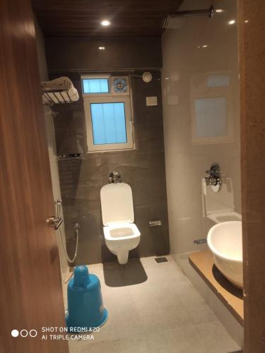 a bathroom with a toilet and a sink at Hotel Dream Residency in Navi Mumbai