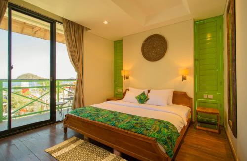 a bedroom with a bed and a large window at Eco Tree O'tel in Labuan Bajo