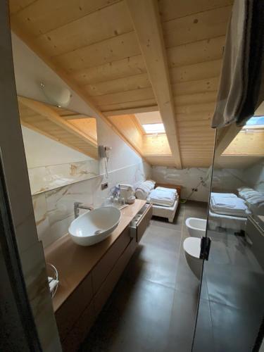 un bagno con due lavandini e un letto in una camera di Villa Claudia a Livigno