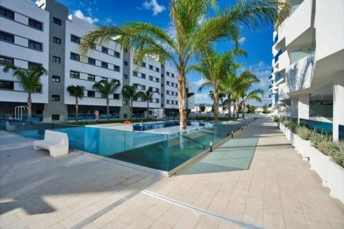 un complejo con piscina con palmeras y un edificio en Lovely apartment with pool in Fuengirola Mijas Costa, en Málaga