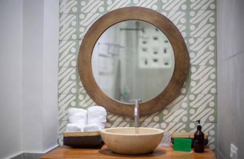 ein Badezimmer mit einem Waschbecken und einem Spiegel auf der Theke in der Unterkunft Eco Tree O'tel in Labuan Bajo