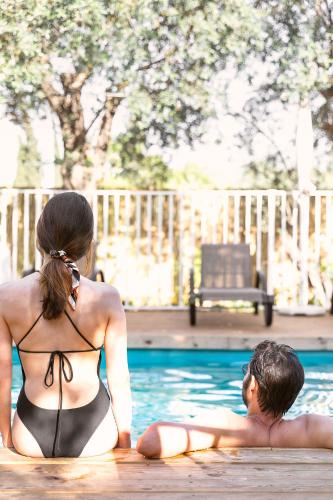 a man and a woman sitting in a swimming pool at מתחם אירוח אוליאה - Olea in Rosh Pinna