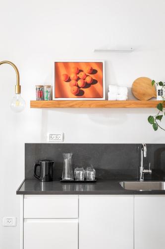 a kitchen with a counter top with a picture on a shelf at מתחם אירוח אוליאה - Olea in Rosh Pinna