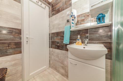 W łazience znajduje się umywalka i lustro. w obiekcie Family blue apartman Montenegro w mieście Baošići