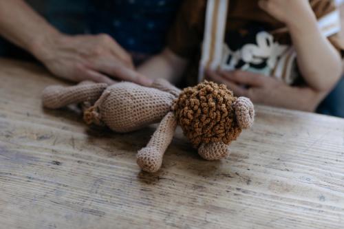 a teddy bear sitting on a wooden table at Hotel Goldener Ochs in Bad Ischl