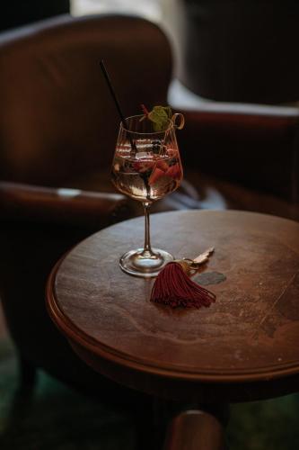 a wine glass sitting on a wooden table at Hotel Goldener Ochs in Bad Ischl