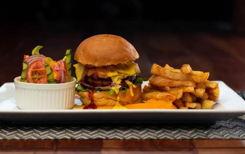 a plate of food with a sandwich and french fries at Dzimbahwe Guest Lodge in Victoria Falls