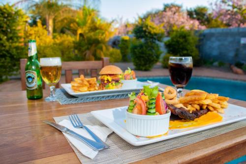 a table with two plates of food and glasses of wine at Dzimbahwe Guest Lodge in Victoria Falls
