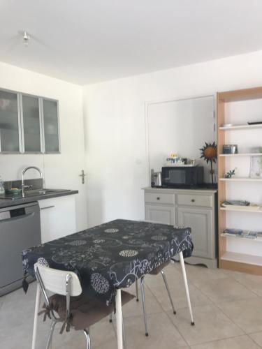 a kitchen with a table in the middle of it at studio neuf climatisé in Les Fumades-Les Bains