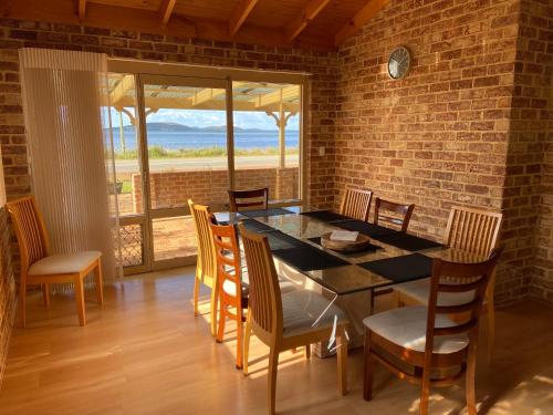 a dining room with a table and chairs and a brick wall at Sunrise House in Albany