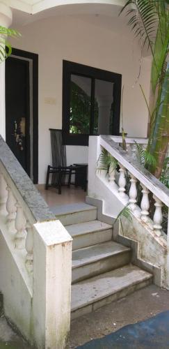 a stairway leading to a house with a porch at God's Gift Morjim in Morjim