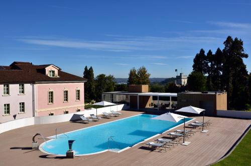 a large swimming pool with lounge chairs and a building at Castello Dal Pozzo in Oleggio Castello