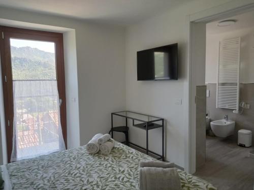 a bedroom with a bed and a bathroom with a window at Monte Zucco Relax self check in in San Pellegrino Terme
