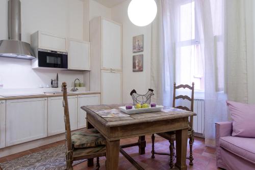 a kitchen with a table with a bowl of fruit on it at L'Altana City House in Brescia