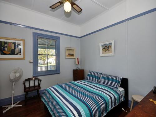 a bedroom with a bed and a ceiling fan at Where the River Runs in Tea Gardens