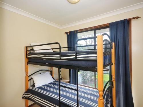 two bunk beds in a room with a window at Pet Friendly on Pelican Close to Myall River in Hawks Nest