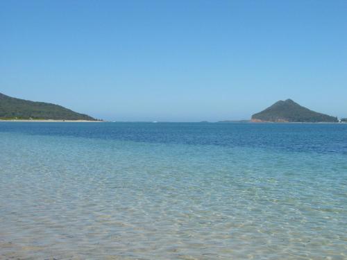 a large body of water with two islands in the distance at Pet Friendly on Pelican Close to Myall River in Hawks Nest