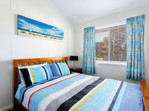 a bedroom with a bed and a window at Surfs Up in Hawks Nest