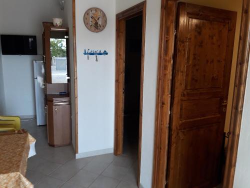 Zimmer mit Tür und Uhr an der Wand in der Unterkunft VILLETTA SALENTO S.M.DI LEUCA 6 POSTI LETTO in Corsano