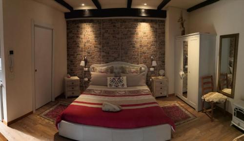 1 dormitorio con 1 cama grande frente a una pared de ladrillo en Country Home B&B Il Melo, en Vicenza