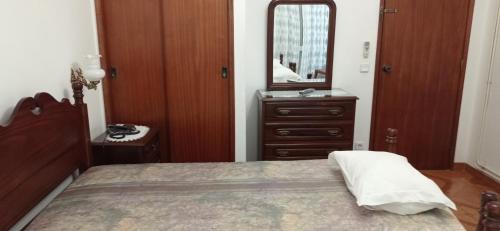 sypialnia z łóżkiem, komodą i lustrem w obiekcie Hotel Primavera w mieście Monte Real