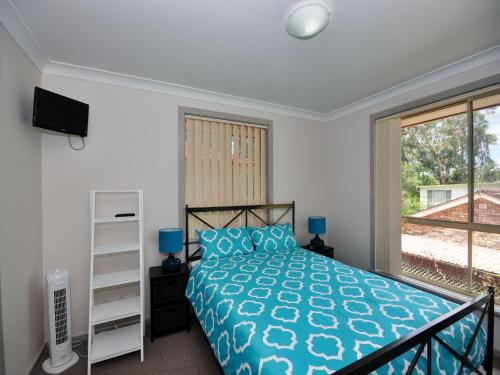 a bedroom with a bed and a large window at Close to Jimmys Beach in Hawks Nest