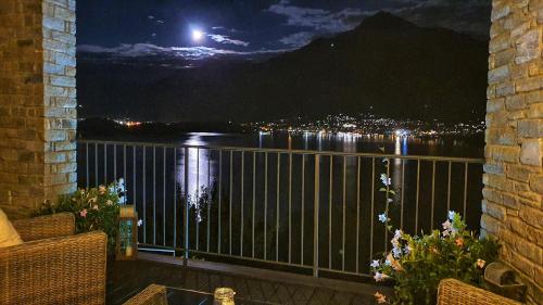 a balcony with a view of the water at night at Il Giardino Di Lory in Vercana