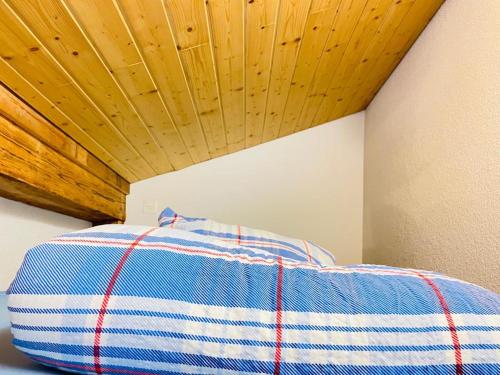 a bed in a room with a wooden ceiling at Royal Swiss Apartments in Ringgenberg