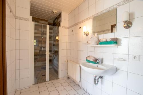 un baño con lavabo y ducha en Apartmenthaus Djuren, en Dornum