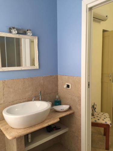 カリアリにあるSu Coccuのバスルーム(白い洗面台、鏡付)