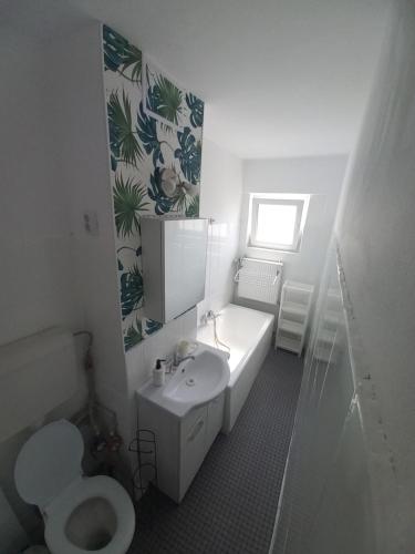 une salle de bain avec des toilettes blanches et un lavabo dans l'établissement Garsoniera Comfort, à Bucarest