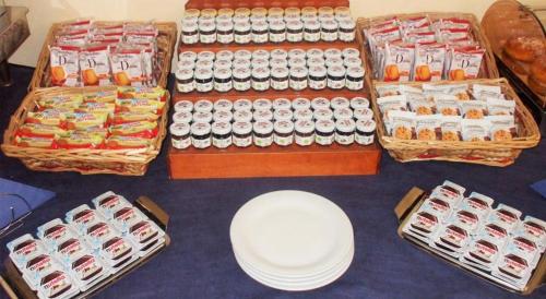 a table topped with lots of bottles and baskets of food at Nicotel Barletta in Barletta