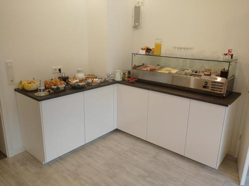 a kitchen with white cabinets and a counter with food on it at Gästehaus Bausch in Mehring