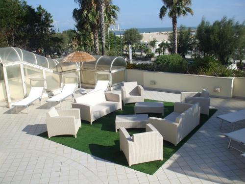 a group of white chairs and tables on a patio at Nicotel Barletta in Barletta