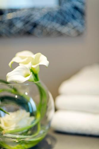 a glass vase filled with white flowers on a table at Hôtel d'Orléans in Orléans