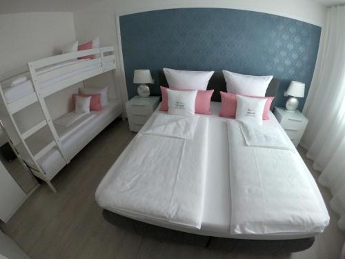a bedroom with two bunk beds and pink pillows at Antike & Modern DELUXE in Günzburg