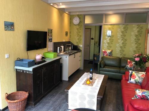Centrum Meppel في ميبل: غرفة معيشة مع أريكة وطاولة ومطبخ