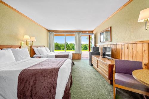 a hotel room with two beds and a television at Green River Lodge in Saluda