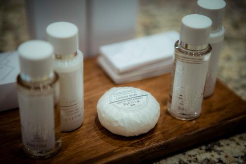 a group of four bottles of soap on a wooden table at Hotel Palace Marina Dinevi in Sveti Vlas