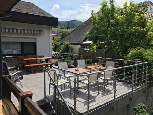 a patio with a table and chairs on a deck at Gästehaus Steuer in Bruttig-Fankel