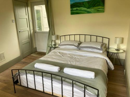 a bedroom with a large bed with two pillows at Sage room Moreton House in Chittoe