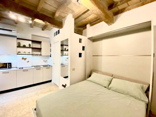 a bedroom with a bed and a kitchen at Little House in Parma