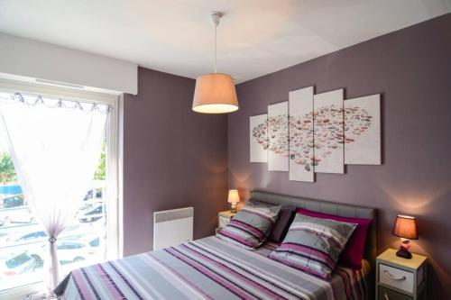 - une chambre avec un lit orné de deux peintures murales dans l'établissement Cosylocation Les Hauts de Port Maria, à Quiberon