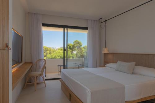 Un dormitorio con una gran cama blanca y una ventana en Hotel Serawa Moraira, en Moraira