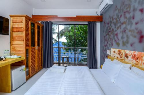 a bedroom with a bed and a large window at Paradise Retreat, Maafushi in Maafushi
