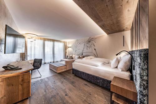 una camera con letto e scrivania di Hotel Berghof Mayrhofen GmbH a Mayrhofen