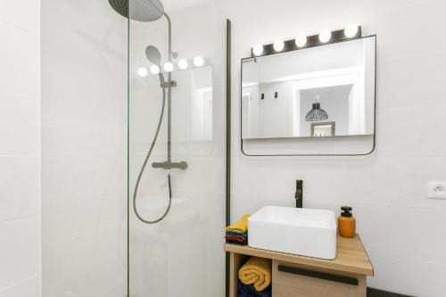 une salle de bain avec une douche, un lavabo et un miroir dans l'établissement Appartement T3 terrasse vue sur mer, piscine, parking, wifi et clim, à Sète