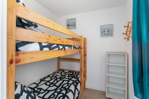 - une chambre avec 2 lits superposés et un miroir dans l'établissement Appartement T3 terrasse vue sur mer, piscine, parking, wifi et clim, à Sète