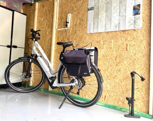 a bike is parked next to a building at Sakura Lodging in Bossut-Gottechain